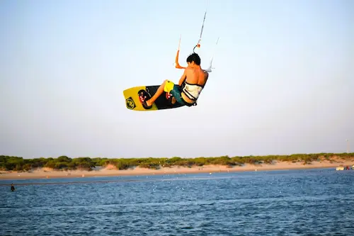 Instructor de nuestra escuela de kitesurf en Huelva asistiendo a un alumno en el agua